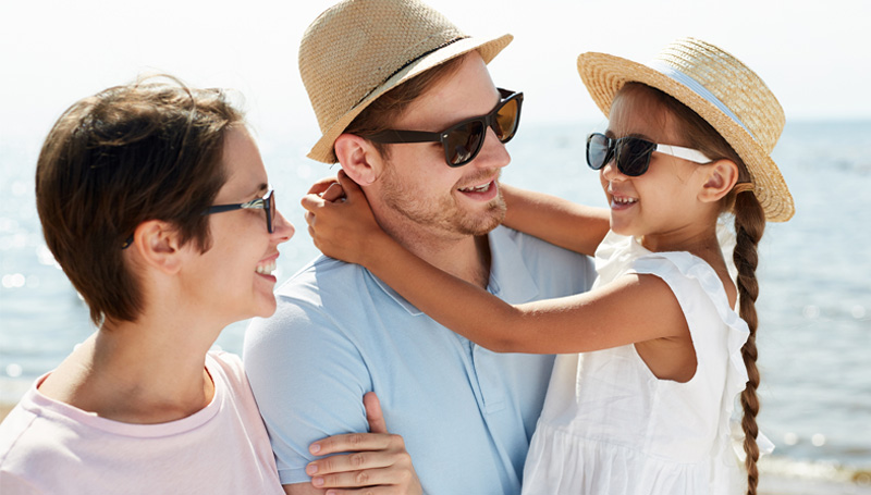 family-wearing-sunglasses-hats-at-beach